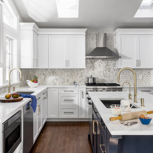 Idées déco pour une cuisine classique en U fermée et de taille moyenne avec un placard à porte shaker, des portes de placard blanches, un plan de travail en quartz, une crédence grise, une crédence en marbre, un électroménager en acier inoxydable, un îlot central, un sol marron, un plan de travail blanc, un évier encastré et un sol en bois foncé.