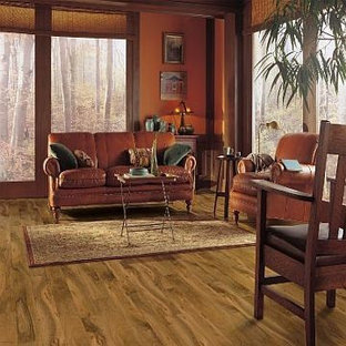 Ejemplo de biblioteca en casa tipo loft, mediterránea, con parades naranjas y suelo laminado