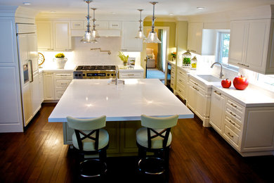 Open concept kitchen - large traditional u-shaped medium tone wood floor open concept kitchen idea in Los Angeles with white cabinets, white backsplash, subway tile backsplash, paneled appliances, an undermount sink, raised-panel cabinets, quartz countertops and an island