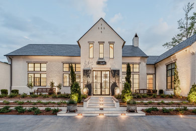 Example of a large transitional white two-story brick exterior home design in Other with a shingle roof
