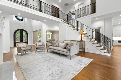 Living room - large transitional formal and open concept light wood floor, brown floor and wall paneling living room idea in Houston with white walls, a standard fireplace and a stone fireplace