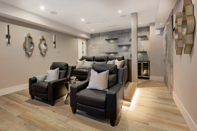 Ejemplo de cine en casa cerrado minimalista de tamaño medio con paredes grises, suelo vinílico, pared multimedia y suelo marrón