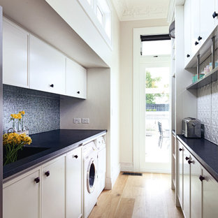 Große Klassische Küche in L-Form mit Vorratsschrank, Landhausspüle, profilierten Schrankfronten, weißen Schränken, Quarzit-Arbeitsplatte, Küchenrückwand in Weiß, weißen Elektrogeräten, hellem Holzboden und zwei Kücheninseln in Auckland