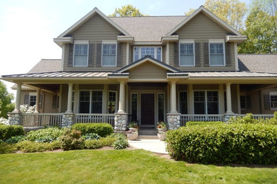 Inspiration for a large rustic beige two-story wood exterior home remodel in Grand Rapids with a hip roof