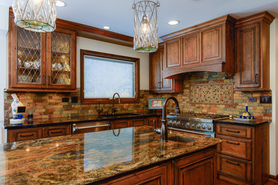Example of a large mountain style kitchen design in Chicago with an undermount sink, raised-panel cabinets, granite countertops, stone tile backsplash, stainless steel appliances and an island