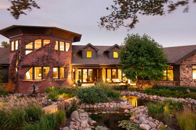 Mountain style brown two-story mixed siding exterior home photo in Omaha with a shingle roof and a brown roof