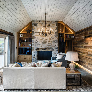 Design ideas for a coastal family and games room in Cheshire with brown walls, concrete flooring, a standard fireplace, a stone fireplace surround, a built-in media unit and grey floors.