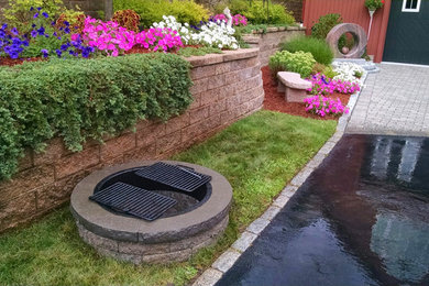Mid-sized elegant front yard brick patio photo in Boston with a fire pit and no cover