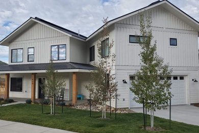 Inspiration for a mid-sized country white two-story wood house exterior remodel in Denver with a hip roof and a metal roof