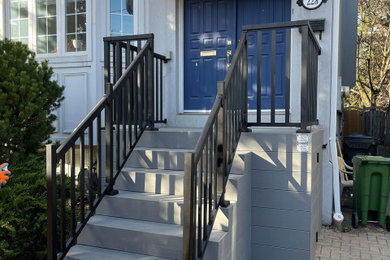 Trendy metal railing front porch idea in Toronto with decking