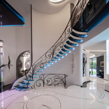 Amazing floating staircase with cantileverd glass treads and artistic balustrade