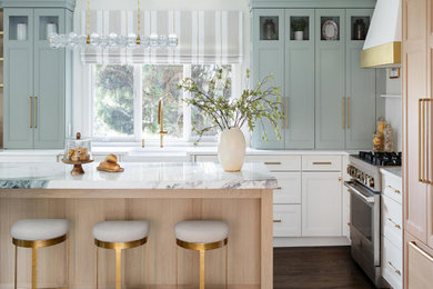 Enclosed kitchen - large transitional l-shaped dark wood floor and brown floor enclosed kitchen idea in New York with a farmhouse sink, recessed-panel cabinets, blue cabinets, marble countertops, white backsplash, stainless steel appliances, an island and white countertops