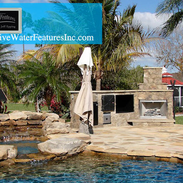 Tropical backyard room with pool waterfall, fireplace, and koi pond