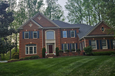 Inspiration for a large timeless two-story brick house exterior remodel in DC Metro with a hip roof, a shingle roof and a gray roof