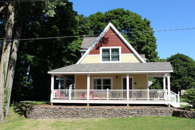 Mid-sized traditional yellow two-story wood gable roof idea in Other