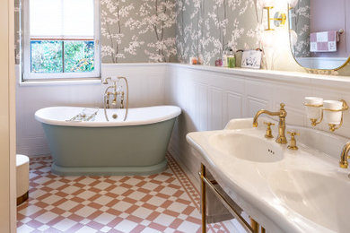 Imagen de cuarto de baño doble y de pie tradicional grande con bañera exenta, baldosas y/o azulejos blancos, paredes blancas, suelo de baldosas de cerámica, lavabo tipo consola y papel pintado