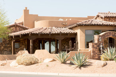 Example of a mid-sized mountain style beige one-story stucco exterior home design in Phoenix