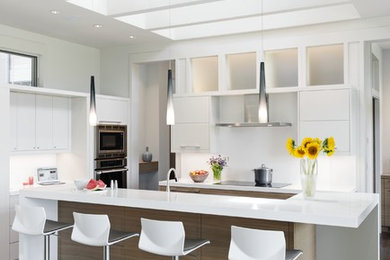 Inspiration for a contemporary u-shaped medium tone wood floor open concept kitchen remodel in Other with flat-panel cabinets, white cabinets, solid surface countertops, white backsplash, black appliances and an island