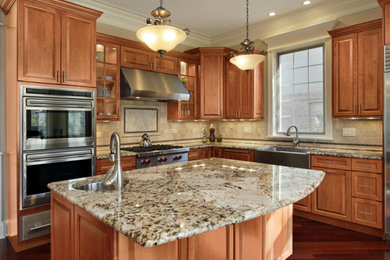 Example of a large classic l-shaped dark wood floor open concept kitchen design in Other with shaker cabinets, medium tone wood cabinets, granite countertops, beige backsplash, stone tile backsplash, stainless steel appliances and an island