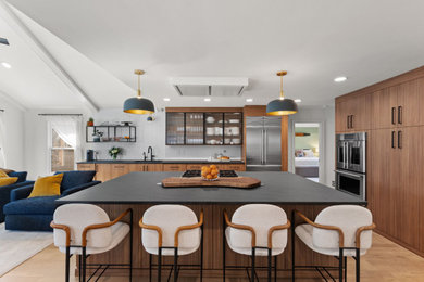 Trendy l-shaped light wood floor and beige floor kitchen photo in Atlanta with an undermount sink, flat-panel cabinets, medium tone wood cabinets, white backsplash, subway tile backsplash, stainless steel appliances, an island and gray countertops