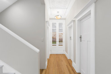 Foto de recibidores y pasillos clásicos con suelo de madera clara