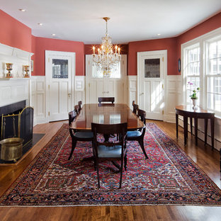Idées déco pour une très grande salle à manger classique fermée avec un mur rouge, un sol en bois brun, une cheminée standard et un manteau de cheminée en bois.