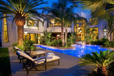 Pool - large contemporary backyard stamped concrete and custom-shaped lap pool idea in Las Vegas