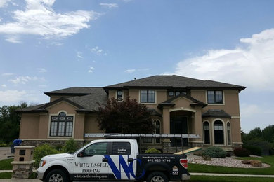 Inspiration for a large mediterranean beige two-story house exterior remodel in Omaha with a hip roof and a tile roof