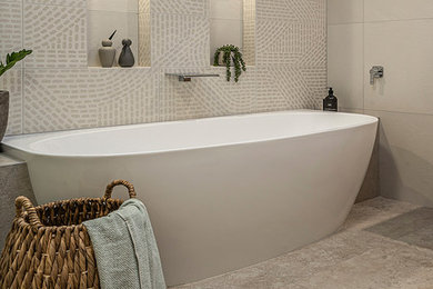 Photo of a large contemporary kids bathroom in Melbourne with flat-panel cabinets, medium wood cabinets, a freestanding tub, a curbless shower, a one-piece toilet, white tile, porcelain tile, white walls, porcelain floors, an integrated sink, solid surface benchtops, beige floor, a hinged shower door and white benchtops.