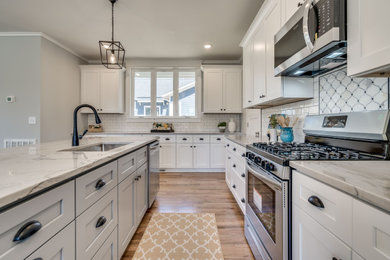 Mid-sized cottage galley light wood floor eat-in kitchen photo in Raleigh with a single-bowl sink, shaker cabinets, white cabinets, quartzite countertops, white backsplash, subway tile backsplash, stainless steel appliances, an island and white countertops
