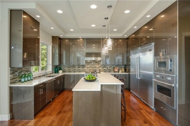 Eat-in kitchen - modern u-shaped eat-in kitchen idea in Seattle with flat-panel cabinets and an island