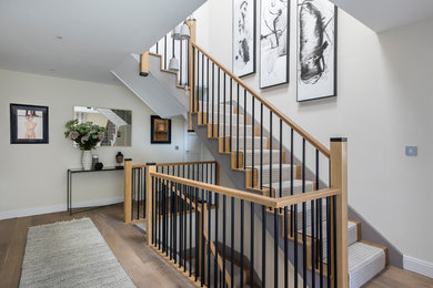 This is an example of a large eclectic wood staircase with wood risers and mixed railing.