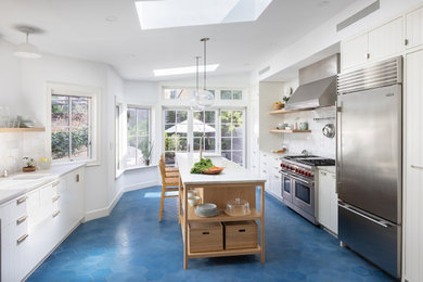 Kitchen - transitional ceramic tile and blue floor kitchen idea in New York with an undermount sink, flat-panel cabinets, white cabinets, white backsplash, ceramic backsplash, an island and white countertops