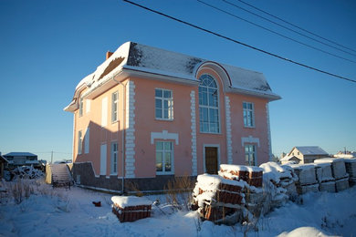 На фото: двухэтажный, красный дом среднего размера в классическом стиле с облицовкой из цементной штукатурки и вальмовой крышей