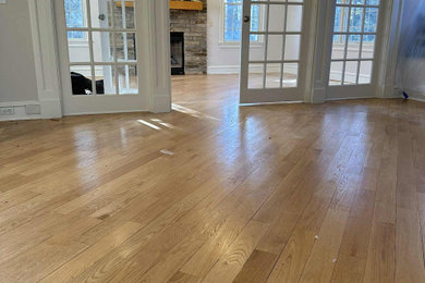 Inspiration for a large timeless enclosed medium tone wood floor and brown floor living room remodel in Orlando with white walls
