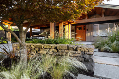 Photo of a mid-century modern full sun front yard concrete paver landscaping in Vancouver.