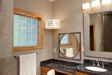 Small traditional master bathroom in Other with raised-panel cabinets, medium wood cabinets, a curbless shower, a one-piece toilet, beige tile, stone tile, grey walls, an undermount sink and granite benchtops.