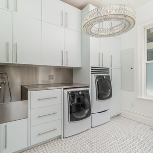 Victorian utility room in San Francisco with flat-panel cabinets, white cabinets, stainless steel worktops, white walls, porcelain flooring, a side by side washer and dryer and white floors.