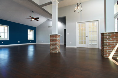 Large transitional open concept living room in Cleveland with grey walls, dark hardwood floors and brown floor.