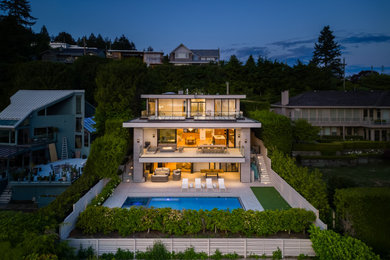 Huge trendy gray three-story wood house exterior photo in Vancouver with a mixed material roof