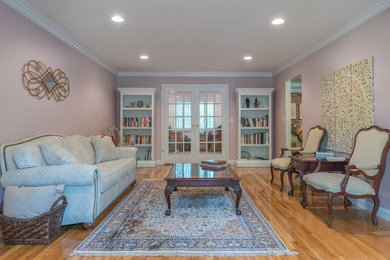Living room - mid-sized traditional formal and enclosed medium tone wood floor and brown floor living room idea in New York with pink walls, no fireplace and no tv
