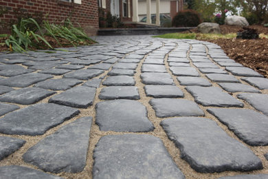 This is an example of a mid-sized rustic full sun front yard concrete paver landscaping in Detroit for fall.