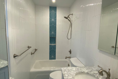 Inspiration for a small modern ensuite bathroom in Philadelphia with white cabinets, an alcove bath, a two-piece toilet, white tiles, ceramic tiles, white walls, porcelain flooring, a submerged sink, marble worktops, turquoise floors, a wall niche, a single sink and a freestanding vanity unit.