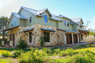 Large arts and crafts green two-story concrete fiberboard exterior home photo in Austin with a metal roof