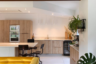 Exemple d'une grande cuisine parallèle et blanche et bois moderne avec un évier encastré, un sol en carrelage de céramique, îlot et poutres apparentes.