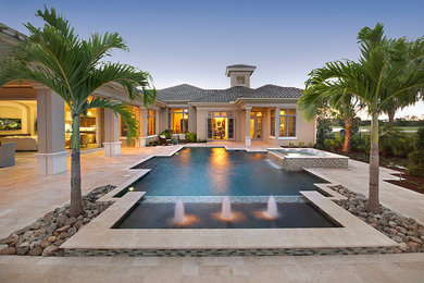 Large tuscan backyard stone and custom-shaped hot tub photo in Phoenix