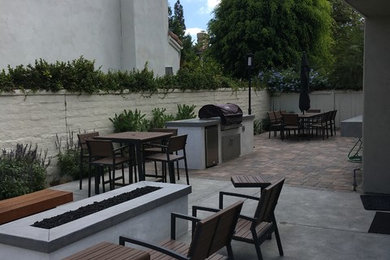 Photo of a mid-sized modern drought-tolerant concrete paver landscaping in Other with a fire pit.