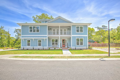 Large arts and crafts blue two-story wood house exterior photo in Other with a shingle roof