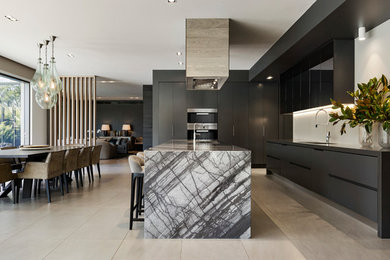 Contemporary galley eat-in kitchen in Melbourne with an undermount sink, flat-panel cabinets, black cabinets, white splashback, black appliances and with island.