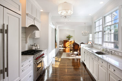 Example of a classic galley medium tone wood floor eat-in kitchen design in New York with an undermount sink, recessed-panel cabinets, white cabinets, marble countertops, gray backsplash, paneled appliances and marble backsplash